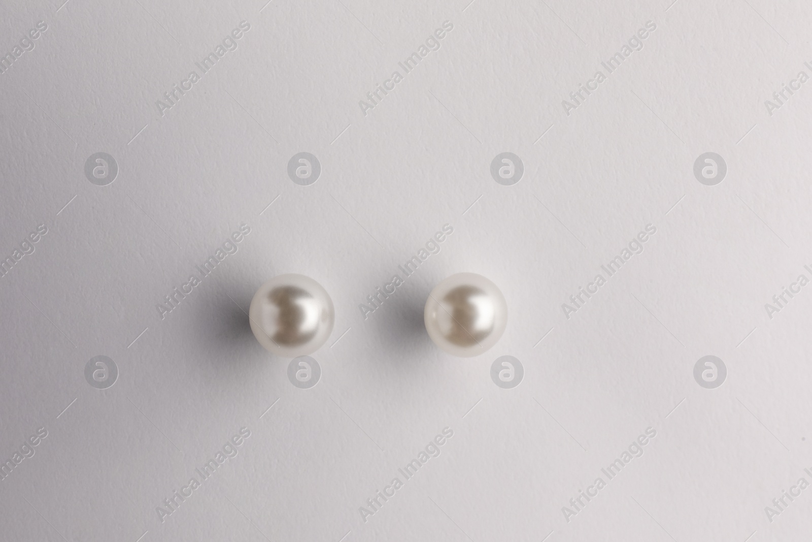 Photo of Elegant pearl earrings isolated on white, top view