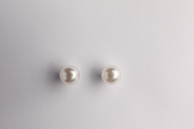 Elegant pearl earrings isolated on white, top view