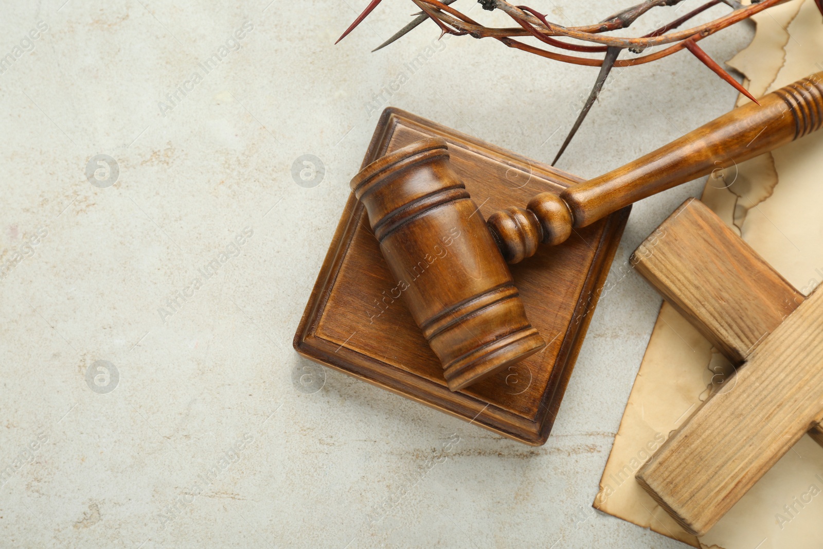 Photo of Judge gavel and wooden cross on light grey table, flat lay. Space for text