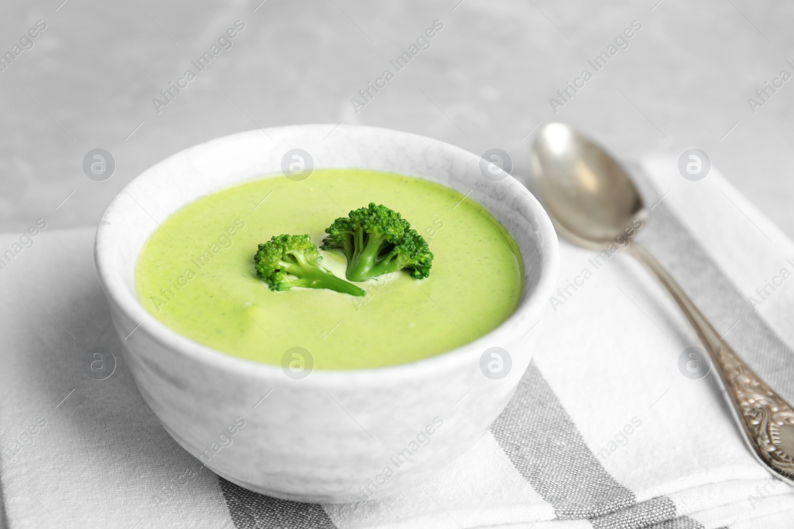 Photo of Delicious broccoli cream soup served on table