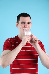 Photo of Milk mustache left after dairy product. Man drinking milk on light blue background