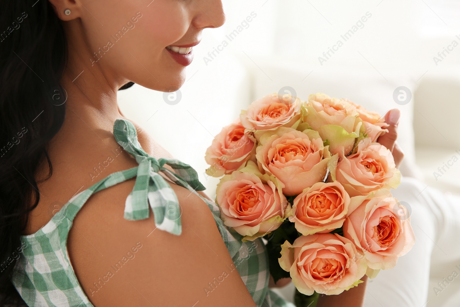 Photo of Young woman with beautiful bouquet indoors, closeup