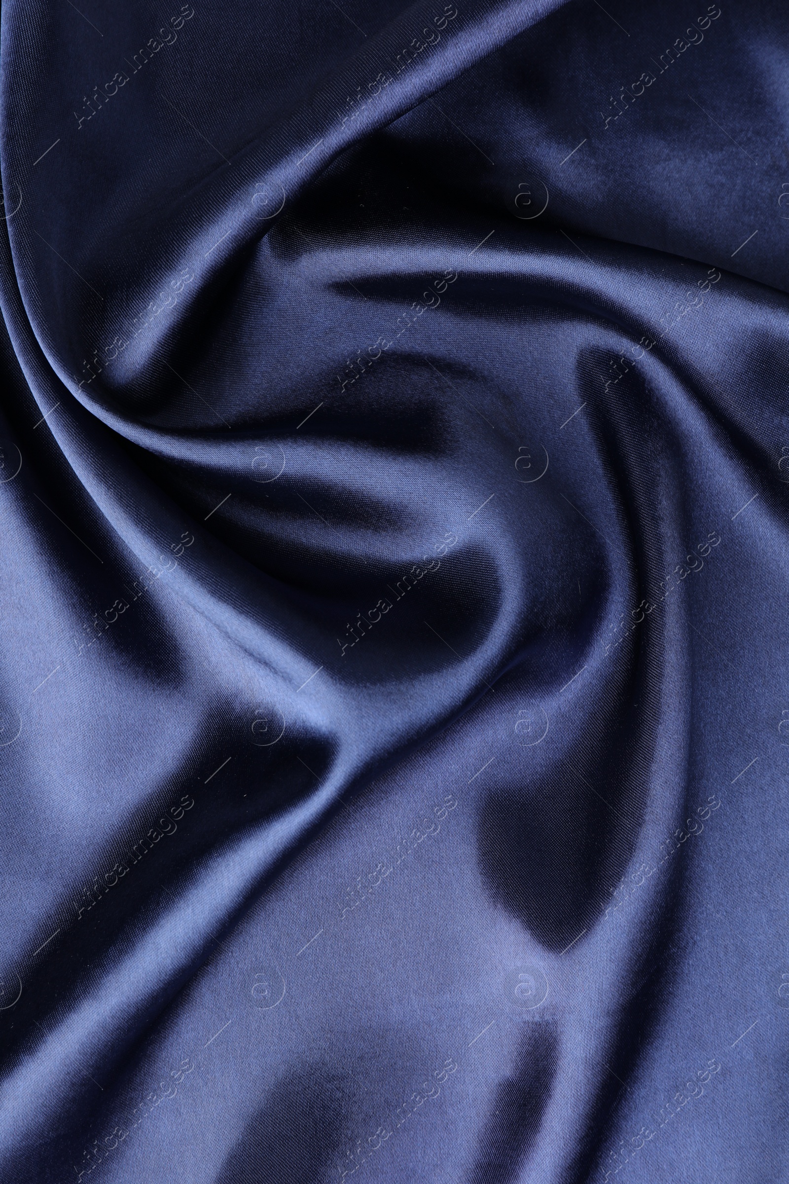 Photo of Crumpled dark blue silk fabric as background, top view