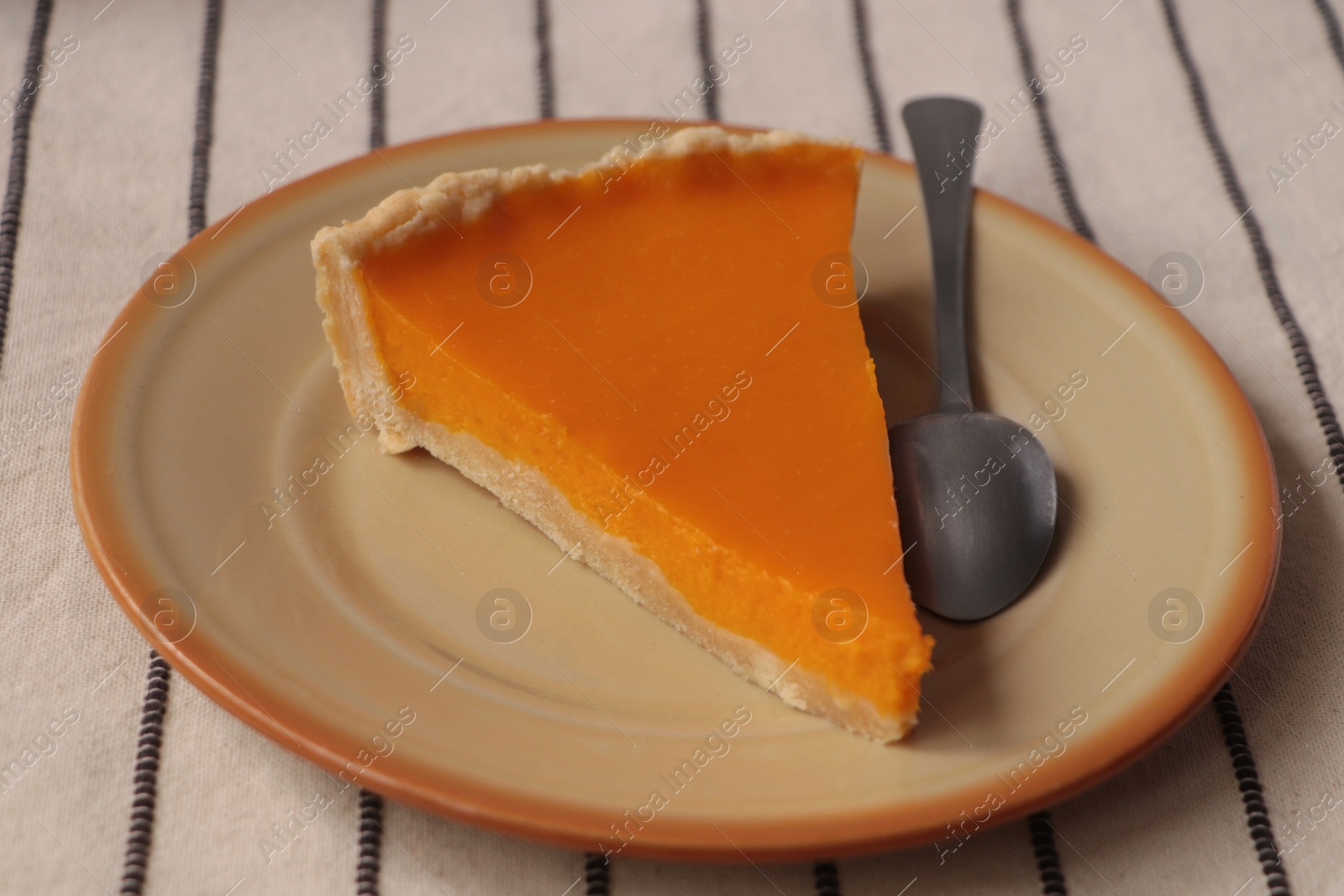 Photo of Plate with piece of fresh homemade pumpkin pie on table