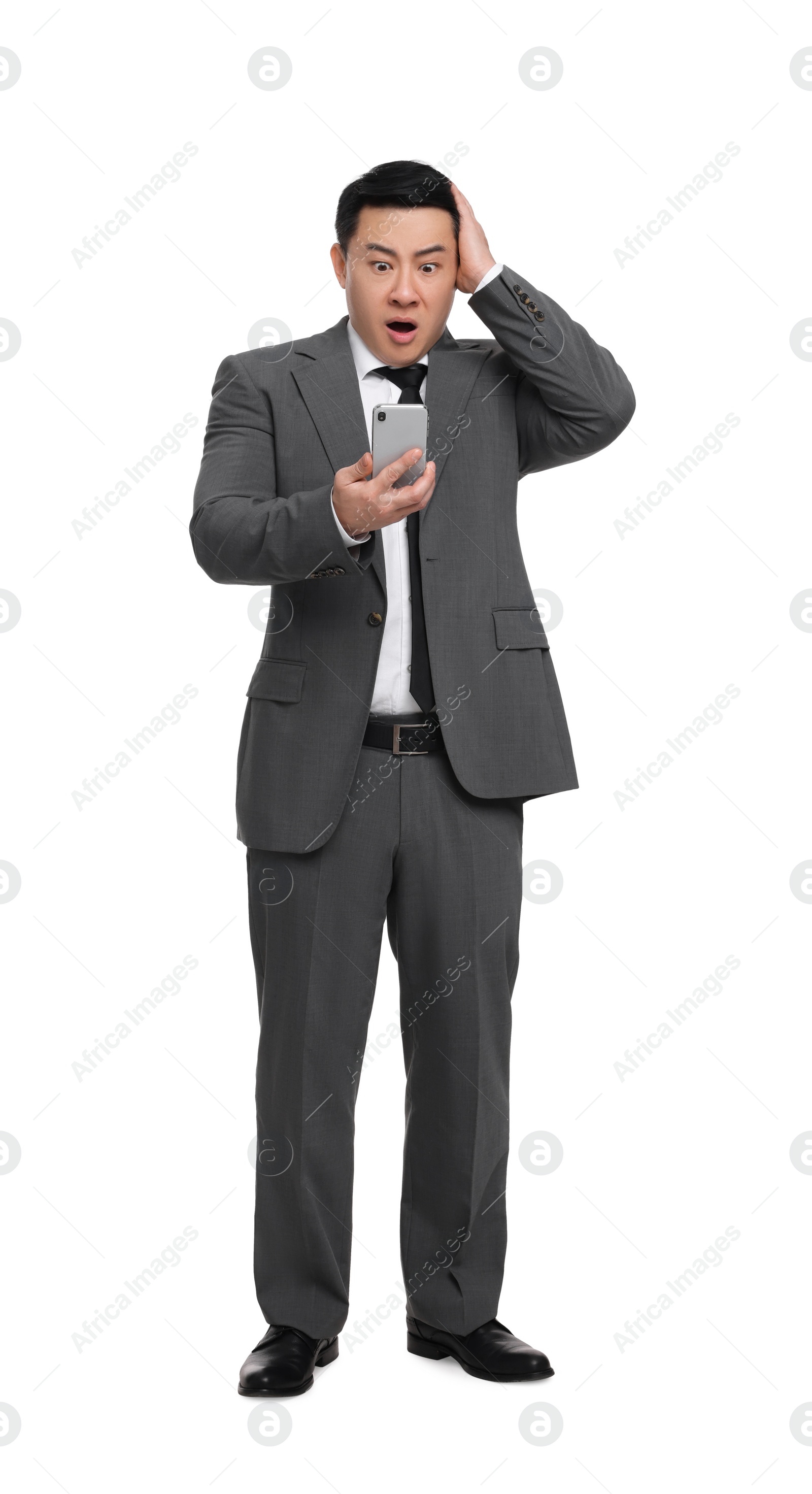 Photo of Shocked businessman in suit with smartphone on white background