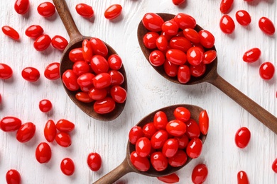 Flat lay composition with fresh ripe goji berries on white wooden table