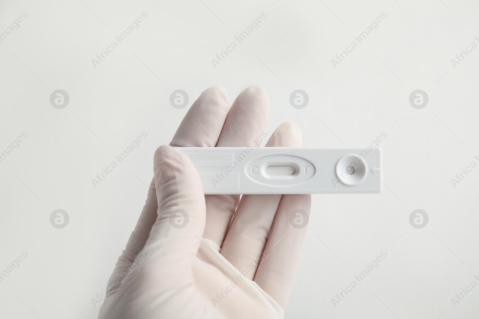 Photo of Doctor holding disposable express test for hepatitis on white background, closeup