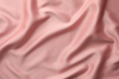 Crumpled pink silk fabric as background, top view