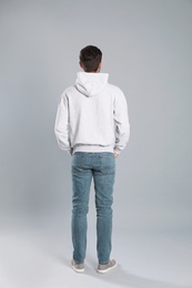 Photo of Young man in sweater on grey background. Mock up for design