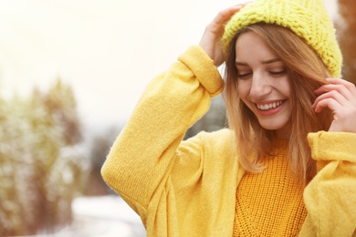 Photo of Young woman in warm clothes outdoors. Winter vacation