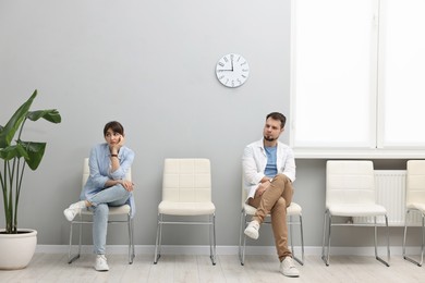 Photo of Man and woman waiting for appointment indoors