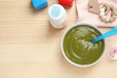 Photo of Flat lay composition with healthy baby food on wooden table, space for text