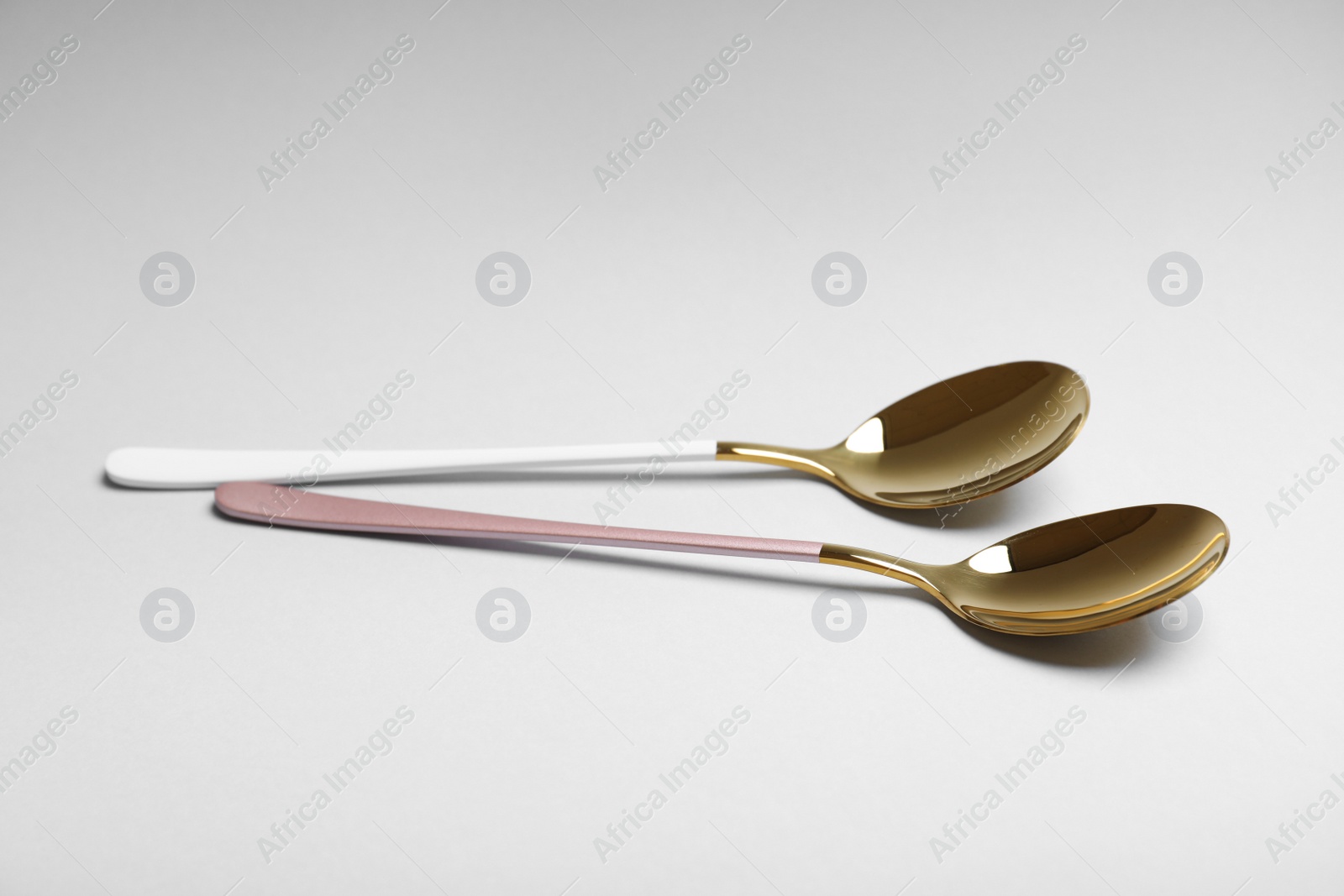 Photo of New shining luxury spoons on white background