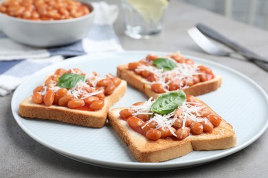 Photo of Toasts with delicious canned beans on light grey table