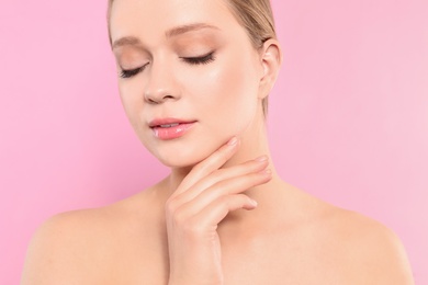 Photo of Portrait of young woman with beautiful face on pink background, closeup