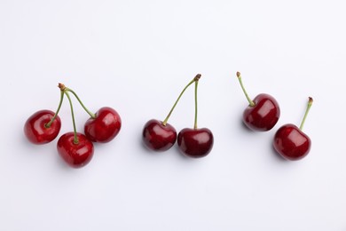 Many ripe sweet cherries on white background, flat lay