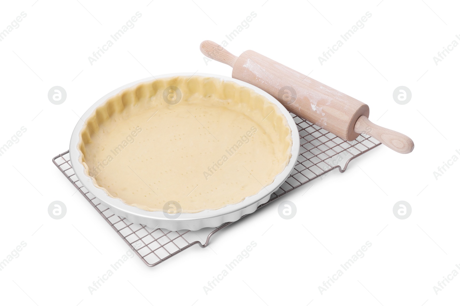 Photo of Quiche pan with fresh dough and rolling pin isolated on white