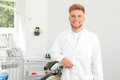 Photo of Portrait of professional dentist in modern clinic. Space for text