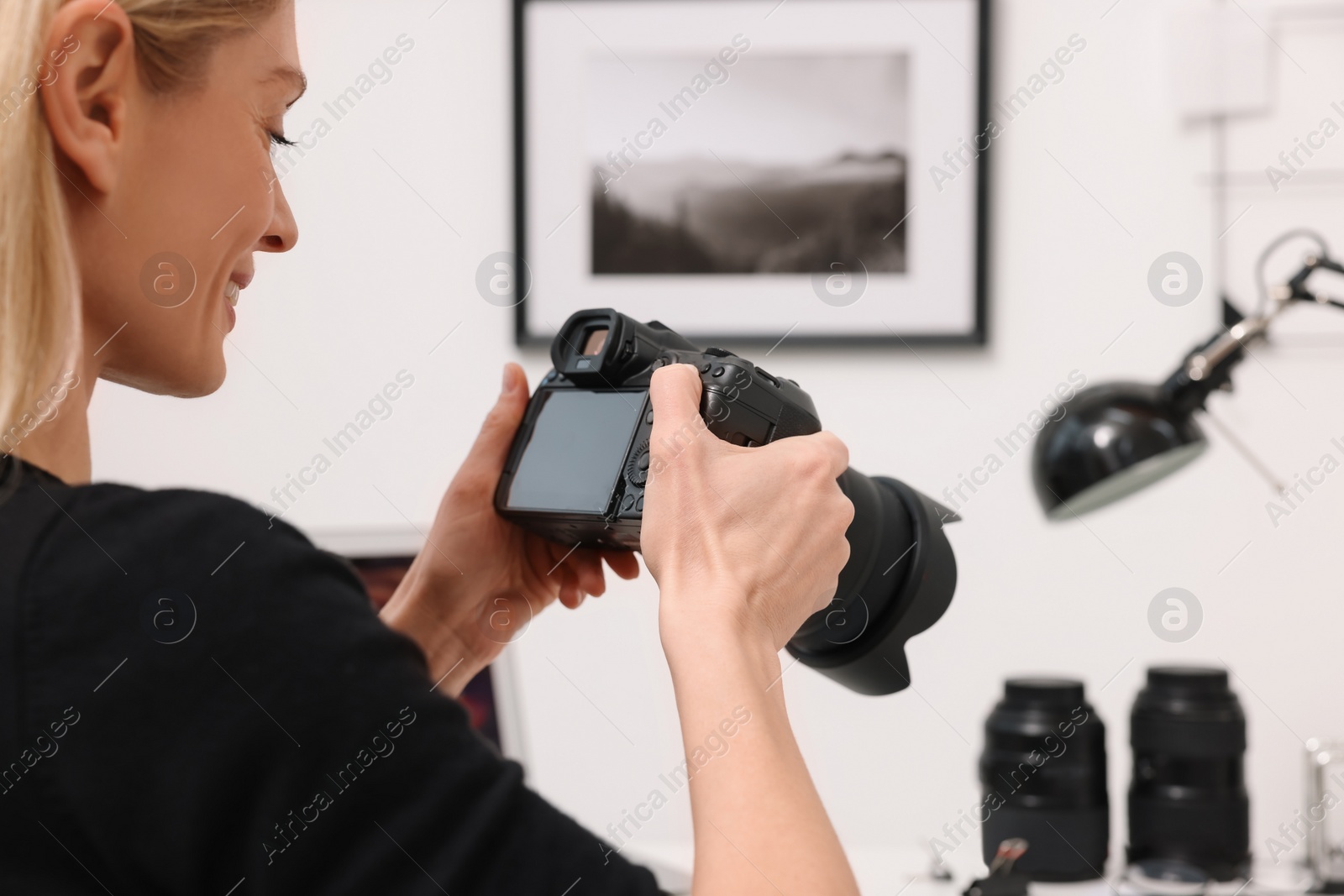 Photo of Professional photographer with digital camera indoors, closeup