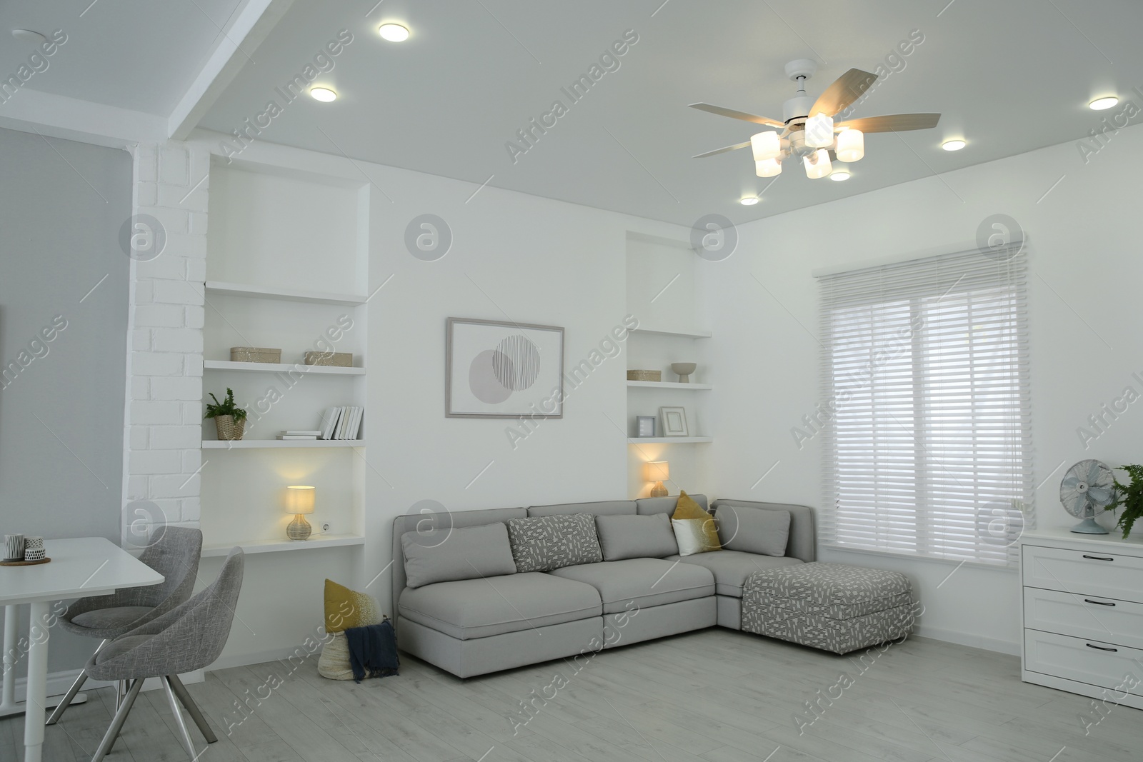 Photo of Comfortable furniture, ceiling fan and accessories in stylish living room
