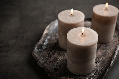 Tray with three burning candles on table. Space for text