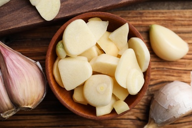 Photo of Fresh chopped garlic on wooden table, flat lay. Organic product