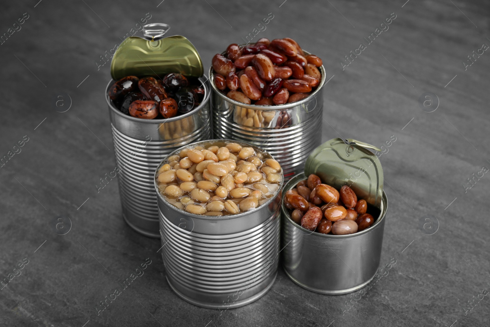 Photo of Tin cans with kidney beans on gray table