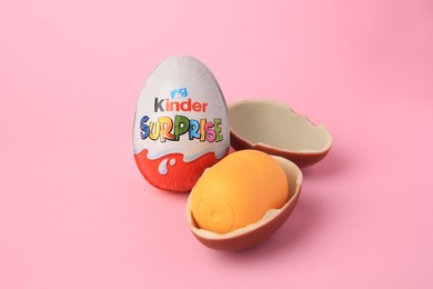 Photo of Slynchev Bryag, Bulgaria - May 25, 2023: Kinder Surprise Eggs and plastic capsule with toy on pink background