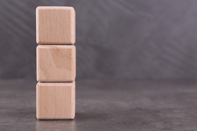 Photo of Wooden cubes with abbreviation ISO on grey textured table. Space for text