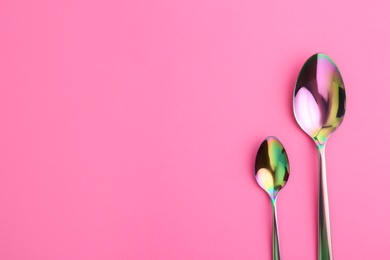 Photo of Clean spoons and space for text on color background, flat lay