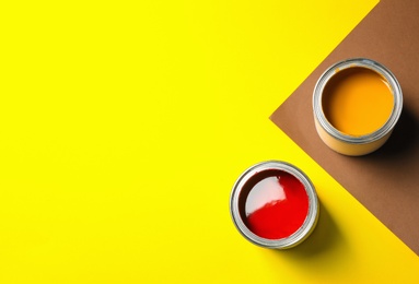 Photo of Flat lay composition with paint cans and space for text on color background