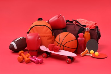 Photo of Many different sports equipment on red background