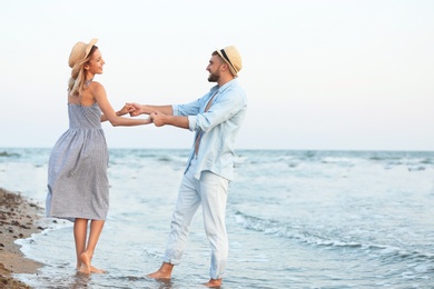 Photo of Happy young couple dancing on beautiful beach