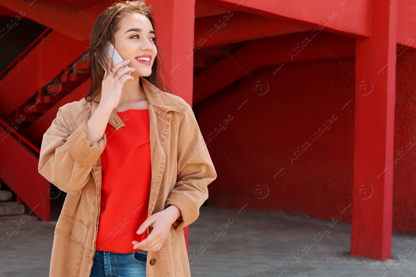 Photo of Young woman talking on mobile phone outdoors