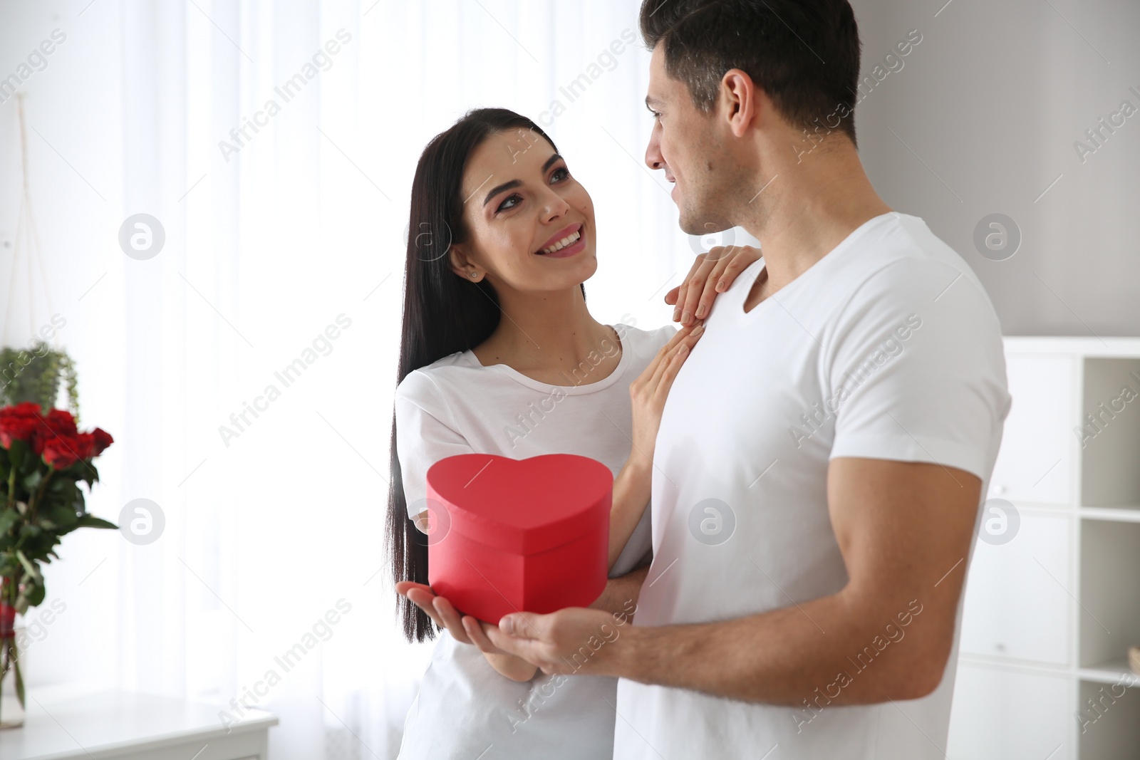 Photo of Lovely couple with gift box at home. Valentine's day celebration