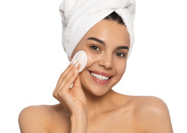 Young woman using cotton pad with micellar water on white background