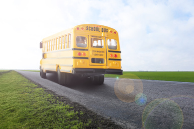 Image of Yellow school bus on road outdoors. Transport for students