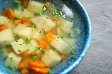 Photo of Bowl of fresh homemade vegetable soup on table, closeup