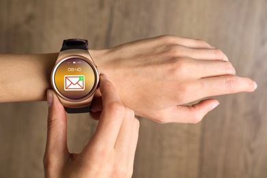Woman checking mail application in smart watch, closeup