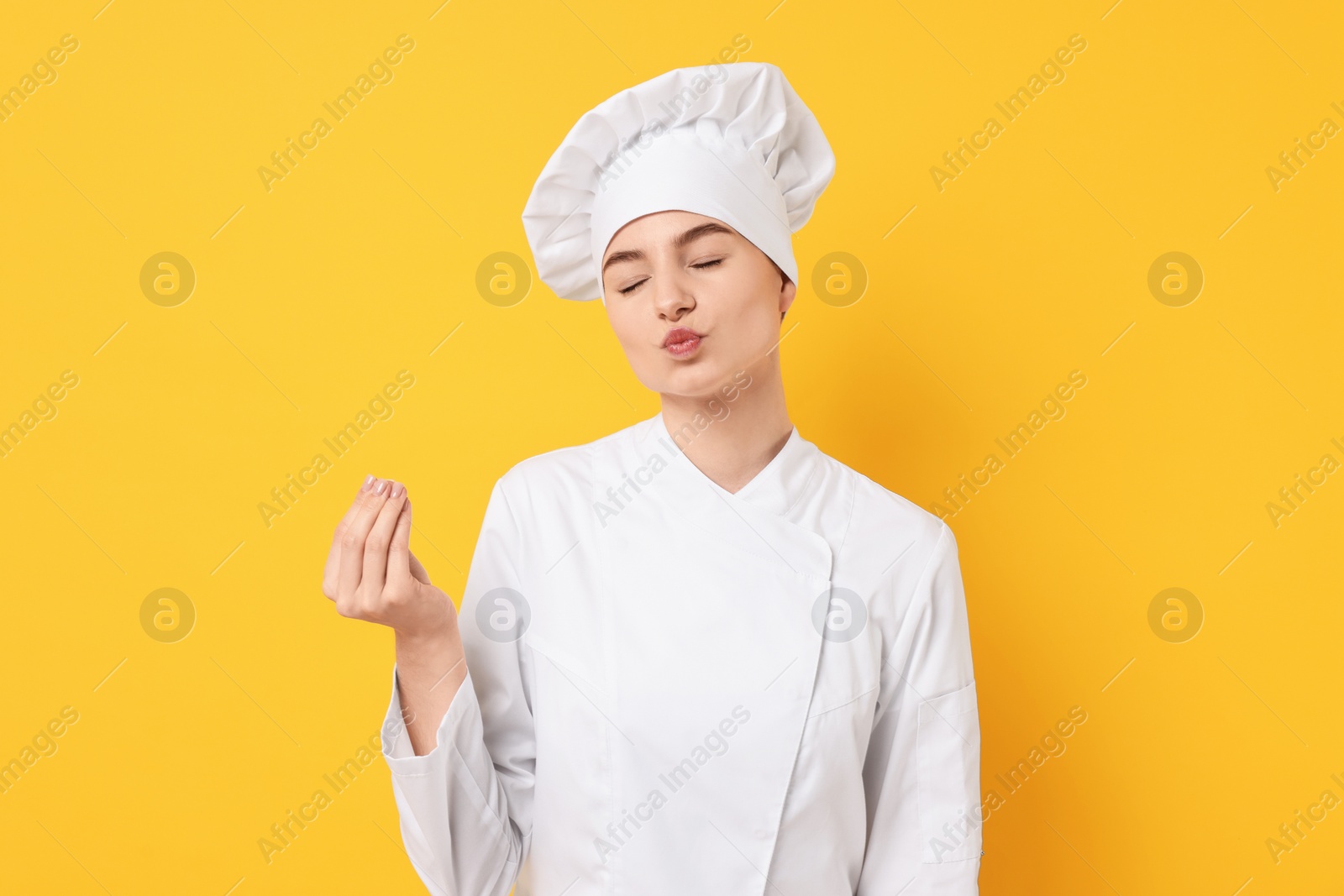 Photo of Professional chef showing perfect sign on yellow background