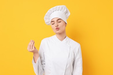 Professional chef showing perfect sign on yellow background