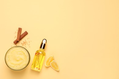 Body scrub in glass jar, oil, lemon and cinnamon on yellow background, flat lay. Space for text