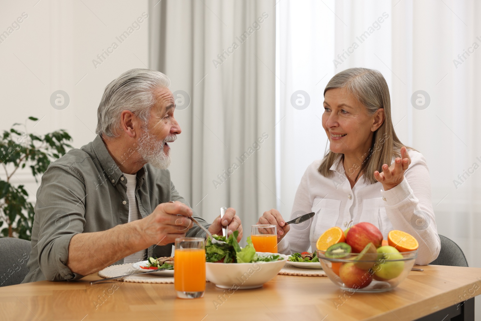 Photo of Happy senior couple having dinner at home