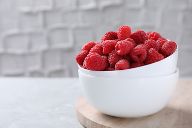 Photo of Delicious fresh ripe raspberries on grey table. Space for text