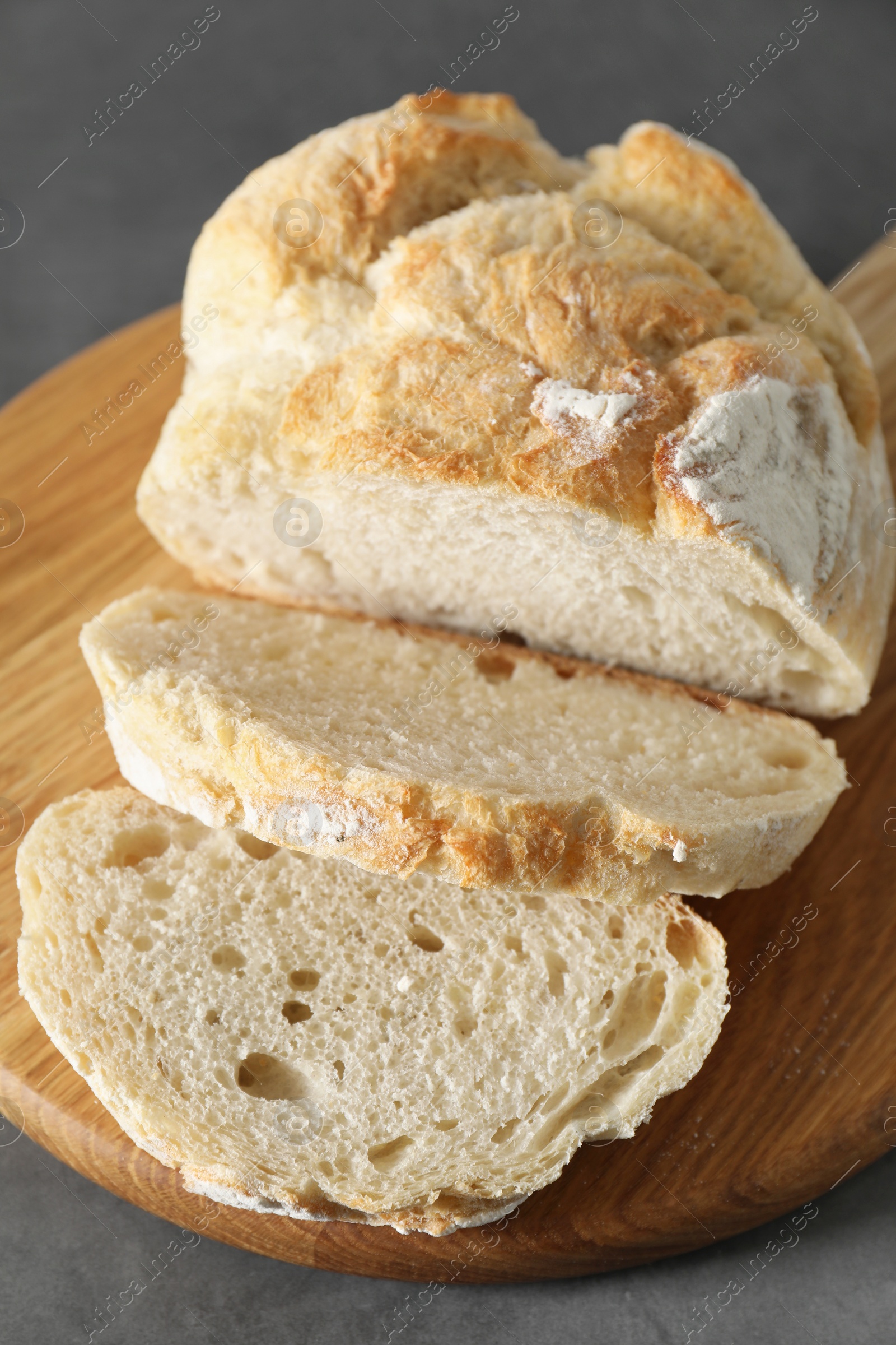 Photo of Freshly baked cut sourdough bread on grey table, closeup