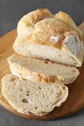 Photo of Freshly baked cut sourdough bread on grey table, closeup