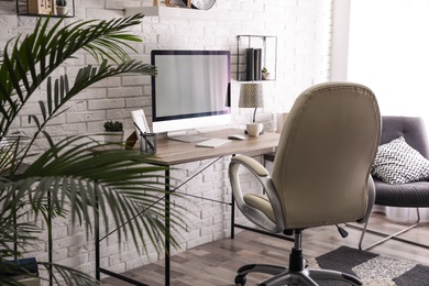 Photo of Comfortable chair near desk in modern office interior