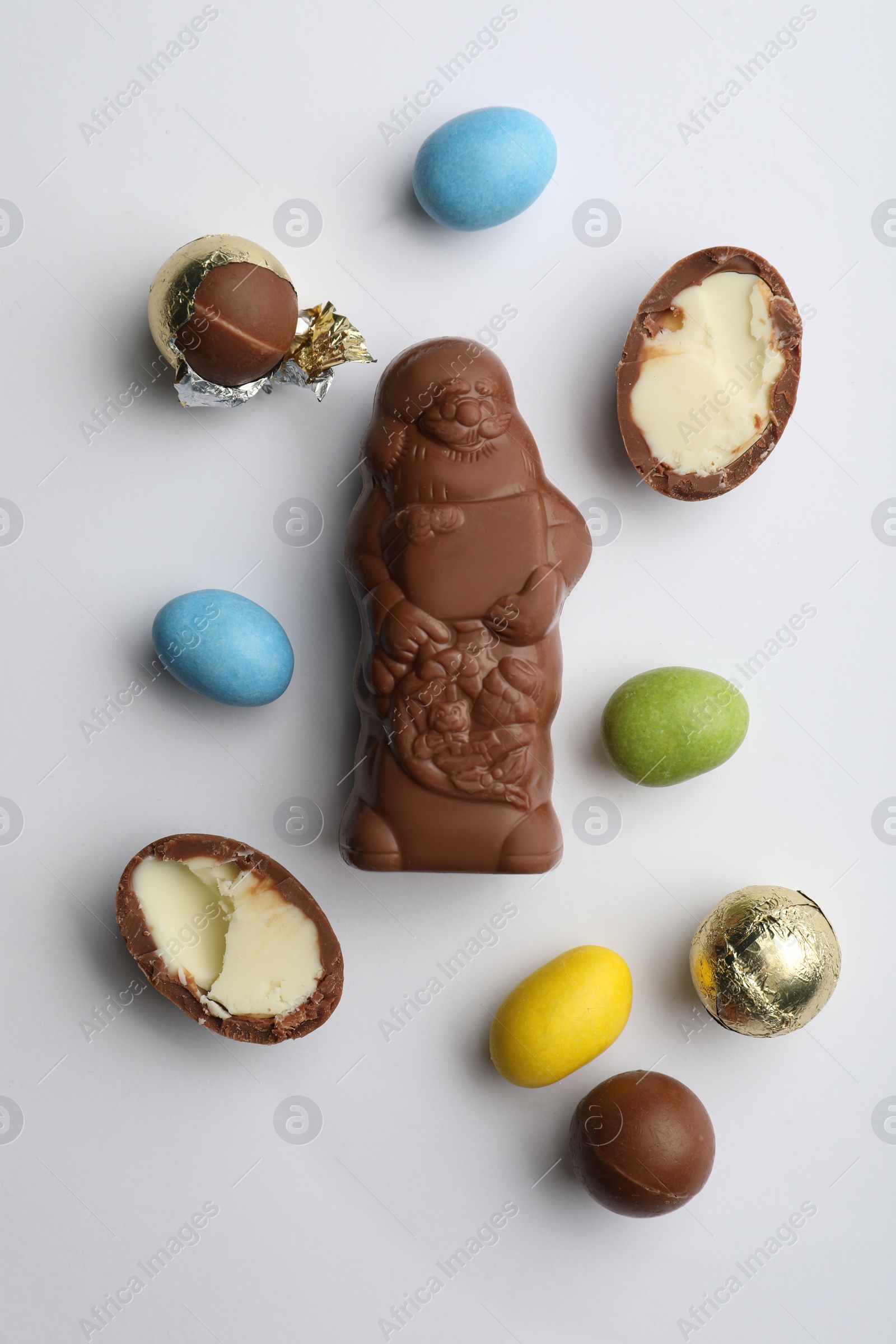 Photo of Flat lay composition with chocolate Santa Claus and sweets on white background