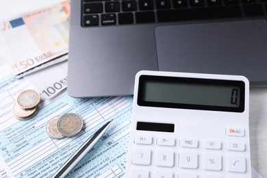 Photo of Tax accounting. Calculator, money, pen, document and laptop on table, closeup