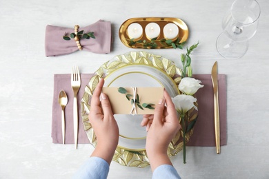 Photo of Woman setting table for festive dinner, top view